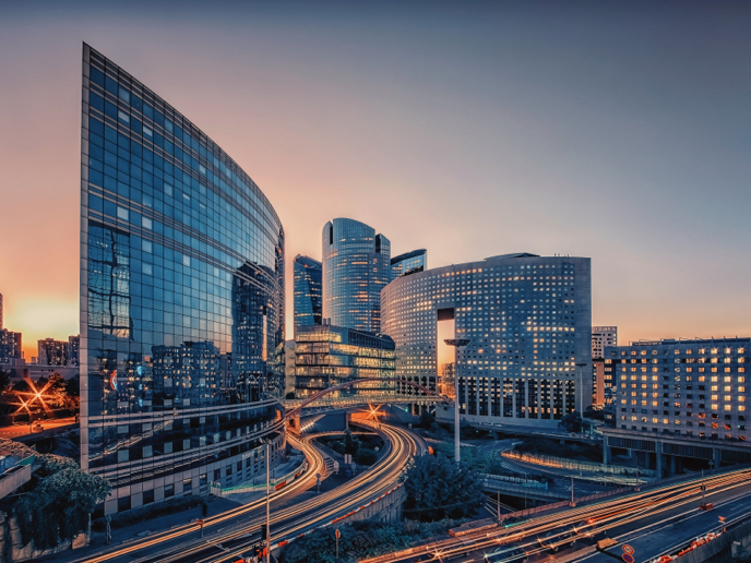 Business district of Paris, France with car-filled roads at sunset.
